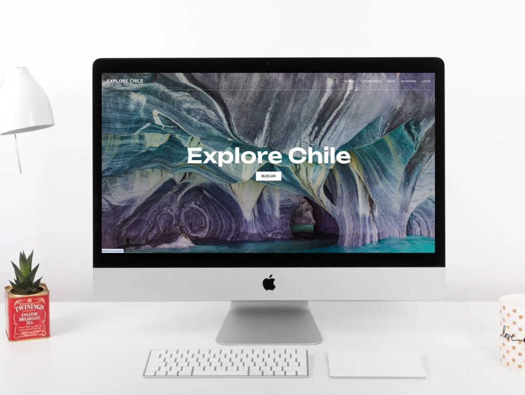 A desktop computer displays a website with the text Explore Chile over a scenic cave image.
