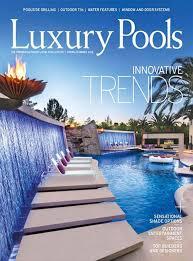 Luxury Pools magazine cover for their website, featuring a modern pool with waterfalls, fire bowl, and palm trees under a blue sky.