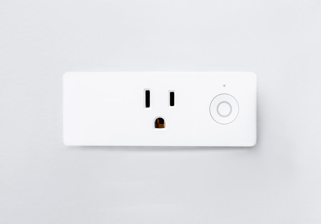 A white smart electrical outlet with a round power button, perfect for integrating into your modern website visuals.