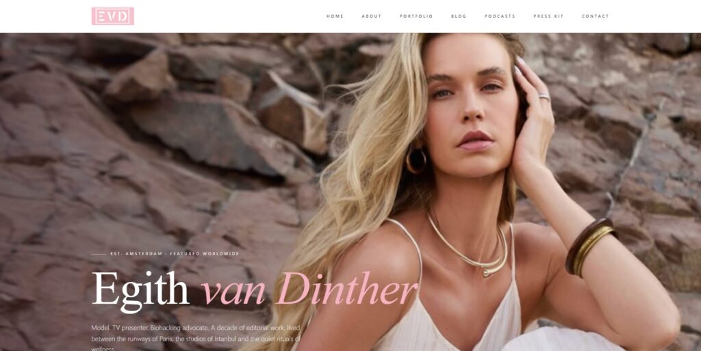 A blonde woman in a white dress poses against a rocky background. She has long hair, wears gold jewelry, and looks confidently at the camera. Text on the image reads Egith van Dinther along with website navigation links.