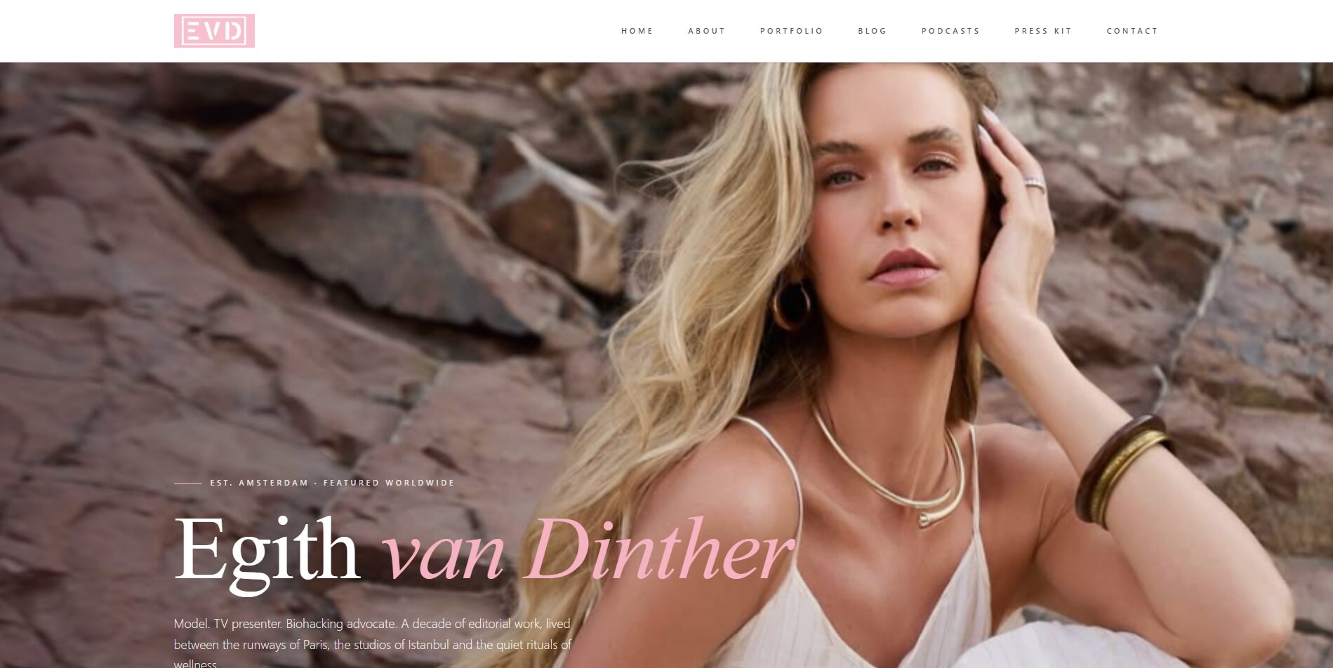 A blonde woman in a white dress poses against a rocky background. She has long hair, wears gold jewelry, and looks confidently at the camera. Text on the image reads Egith van Dinther along with website navigation links.